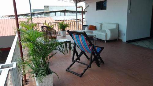 巴兰基亚HOTEL LA CORDIALIDAD的阳台配有椅子、桌子和沙发。