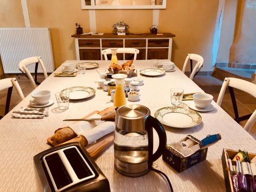 布尔日L’AMANTINE Chambres d’hôtes et gîte的一张桌子,配有白色桌布和茶壶