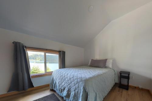 Whale Pass Adventure Apartment的一间卧室设有一张床和一个窗口
