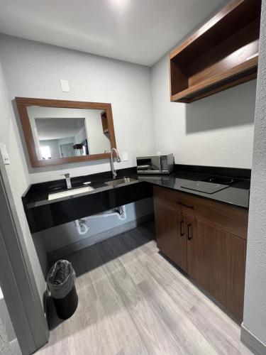 钱诺夫Relax Inn Channelview的一间带水槽和镜子的浴室