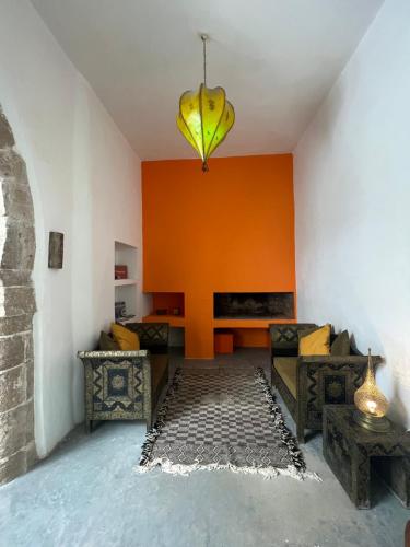 索维拉Riad Dar Sebta的客厅设有橙色墙壁和香蕉吊灯