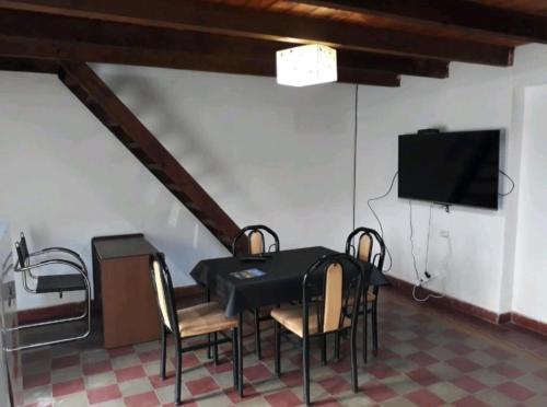 Villa CubasLoft centrico的用餐室配有桌椅和平面电视。