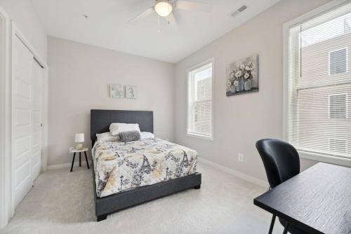 华盛顿Spacious 3Bedroom Duplex with Rooftop Deck!的卧室配有1张床、1张桌子和1把椅子