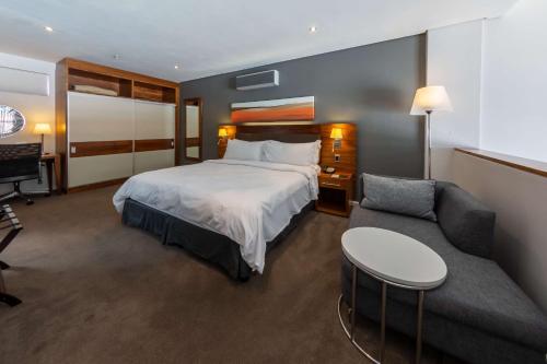 开普敦开普顿上东区希尔顿逸林酒店的酒店客房,配有床和沙发