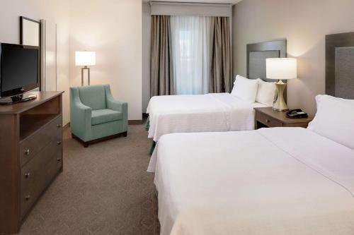 达拉斯达拉斯市场中心希尔顿惠庭套房酒店的酒店客房设有两张床和电视。