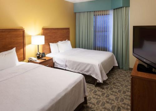 欧文欧文-DFW机场希尔顿惠庭套房酒店的酒店客房设有两张床和一台平面电视。