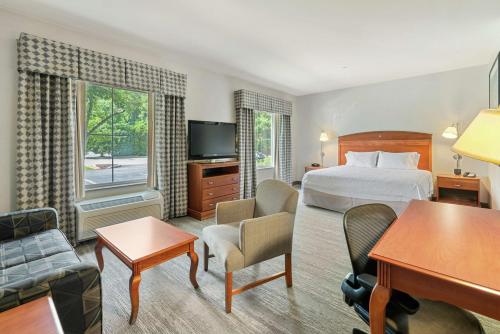 米斯蒂克米斯提希尔顿恒庭旅馆&套房酒店的配有一张床和一张书桌的酒店客房