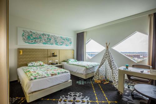 史基浦阿姆斯特丹史基浦机场希尔顿酒店的酒店客房设有两张床、一张书桌和窗户。