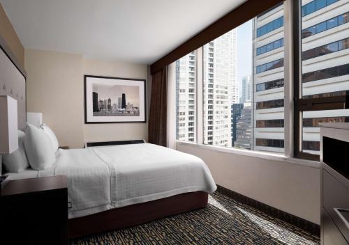 芝加哥Homewood Suites by Hilton Chicago Downtown - Magnificent Mile的酒店客房设有一张床和一个大窗户