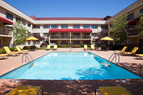 沙伦维尔DoubleTree Suites by Hilton Hotel Cincinnati - Blue Ash的一座带椅子的游泳池以及一座建筑