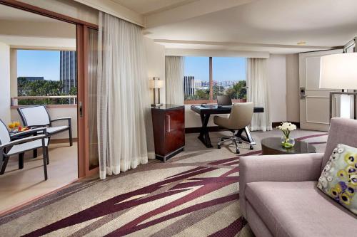 长滩希尔顿长滩酒店 的客厅配有沙发和带书桌的桌子