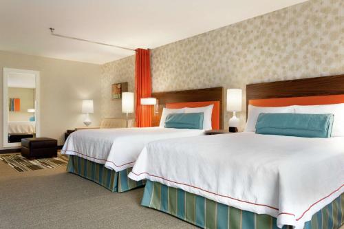 里奇兰Home2 Suites By Hilton Richland的酒店客房带两张大床,带蓝色和红色枕头