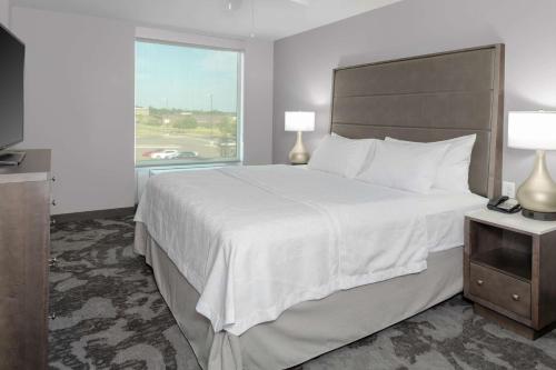 兰辛Homewood Suites By Hilton Lansing Eastwood的一间设有大床和窗户的酒店客房