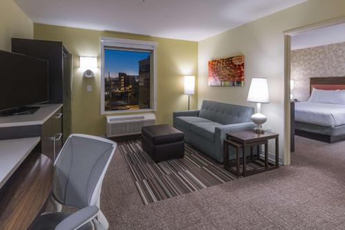 堪萨斯城堪萨斯城市中心第2家园套房酒店的酒店客房配有床、沙发和电视。
