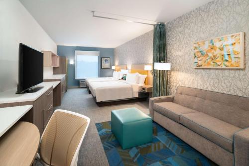 布伦瑞克Home2 Suites By Hilton Brunswick的酒店客房设有一张沙发和一张床
