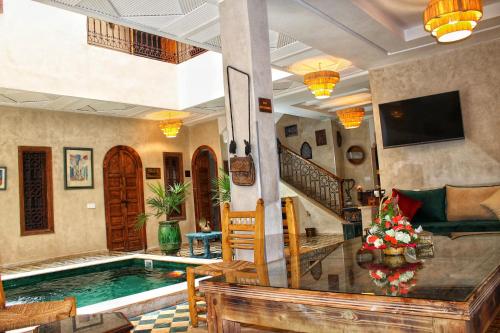 马拉喀什Riad Belikoss Pool & SPA的一个带游泳池和房子的客厅