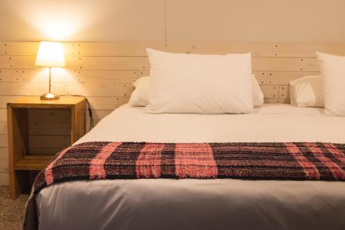 威廉斯港Hotel Fio Fio的一间卧室配有一张大床和一张铺着条纹毯子