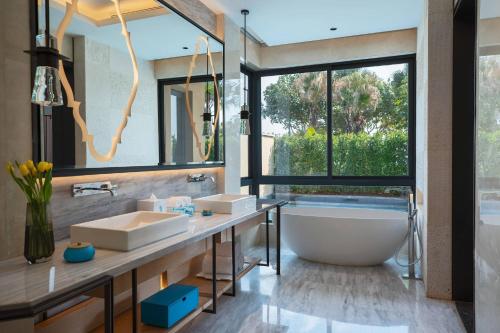 厦门厦门万丽酒店的一间带两个盥洗盆和浴缸的浴室以及大窗户。