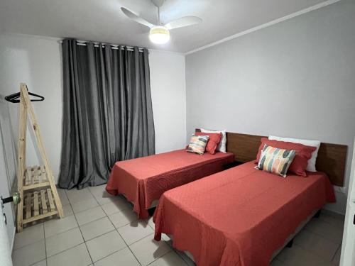 佩鲁伊比AeK apartamento conforto praia的客房设有两张床和窗户。