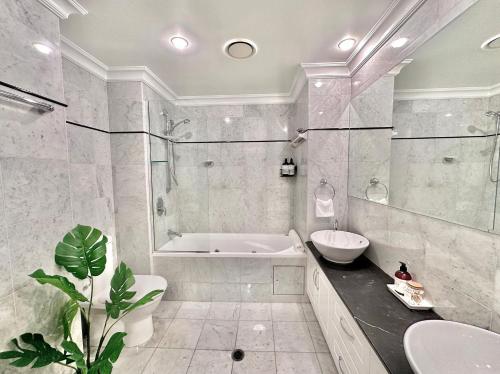 布里斯班麦克阿瑟钱伯斯酒店的带浴缸、卫生间和盥洗盆的浴室
