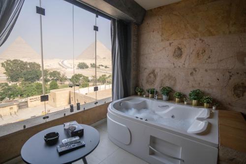 开罗大金字塔酒店 的一间带浴缸的浴室,享有金字塔的景色