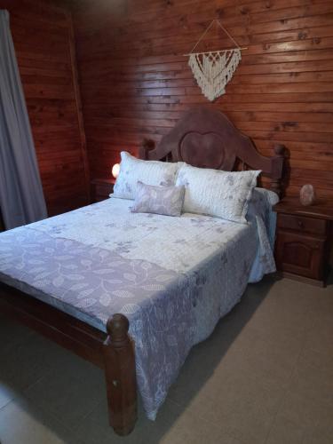 蒂诺加斯塔Cabañas Edna的一间卧室配有一张木墙床