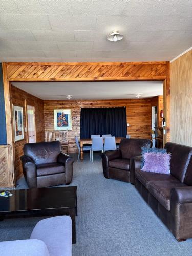 奥阿库尼高山汽车旅馆的客厅配有两张真皮沙发和一张桌子