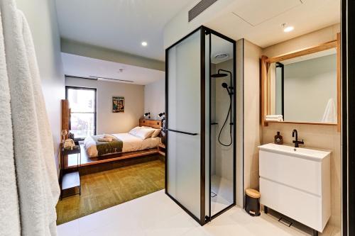 墨尔本Central Club Hotel - North Melbourne的带淋浴的浴室和卧室