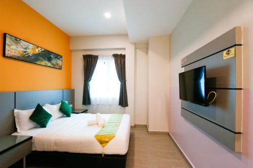 怡保旅悦酒店的一间酒店客房,配有一张床和一台电视