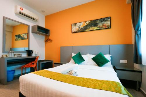 怡保旅悦酒店的酒店客房,配有一张橙色墙壁的床