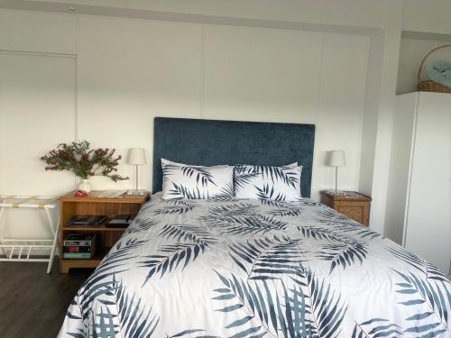 凯里凯里Pickmere Waters的一间卧室配有一张大床和蓝色床头板