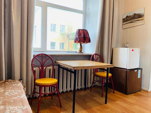 SongiinSongino budget resort的厨房配有桌子、两把椅子和冰箱