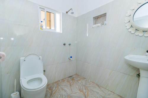 乌昆达Chameleon house diani的白色的浴室设有卫生间和水槽。