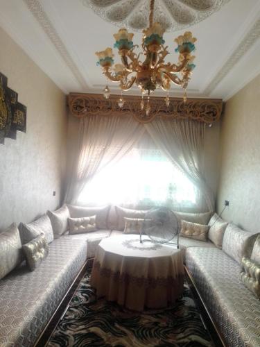 梅克内斯Meknès kamilia的客厅配有一张沙发,窗户前配有一张桌子