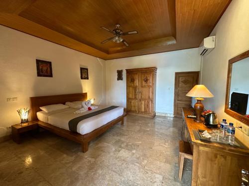甘地达萨Pondok Bambu Resort - 5 Stars Padi Dive Centre的一间卧室配有一张床和吊扇