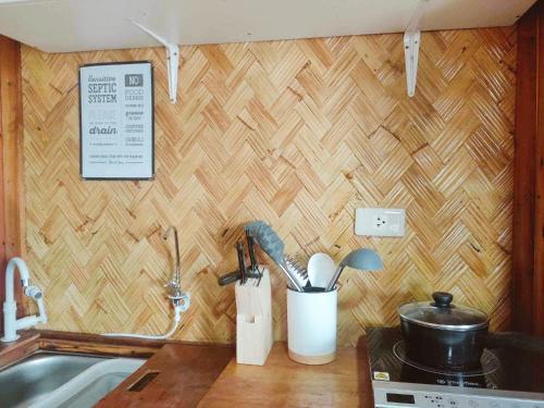 爱妮岛El Nido Backpackers Guesthouse的墙上带餐具的厨房台