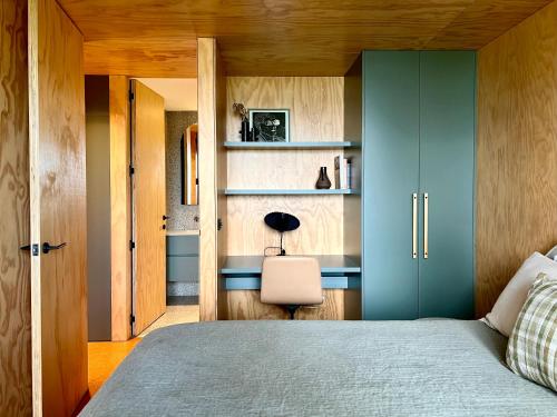 瓦伊河Bridge Rest的一间卧室配有一张带蓝色橱柜的床和一把椅子