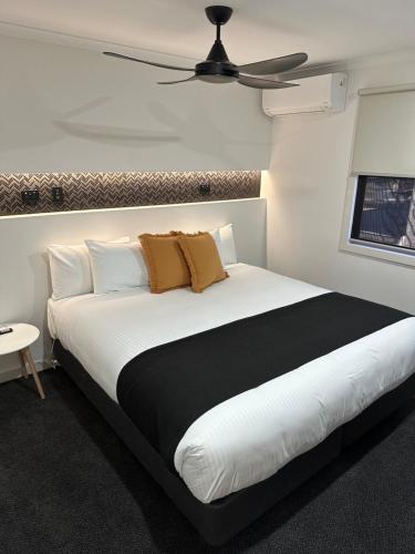 塔姆沃思天堂旅游公园酒店的卧室配有带棕色枕头的大型白色床
