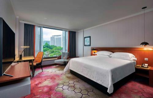 吉隆坡吉隆坡协和酒店的配有一张床、一张书桌和一扇窗户的酒店客房