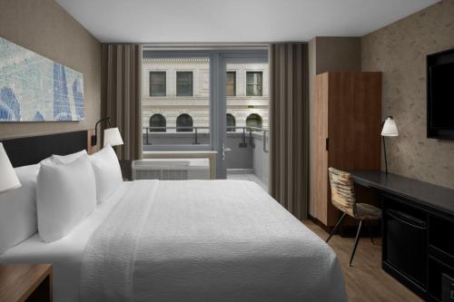 纽约Courtyard by Marriott New York World Trade Center Area的配有一张床、一张书桌和一扇窗户的酒店客房