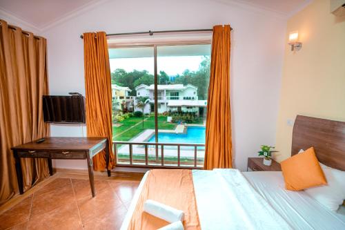 安君纳Atulyam Villa- Anjuna的一间卧室设有一张床和一个享有游泳池景致的窗户。