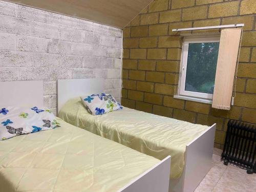 塞凡Tranquil Forest Retreat cozy Cottage near Sevan的客房设有两张床和窗户。