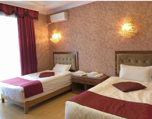 阿克托比Royal_hotel_hostel的酒店客房设有两张床和窗户。