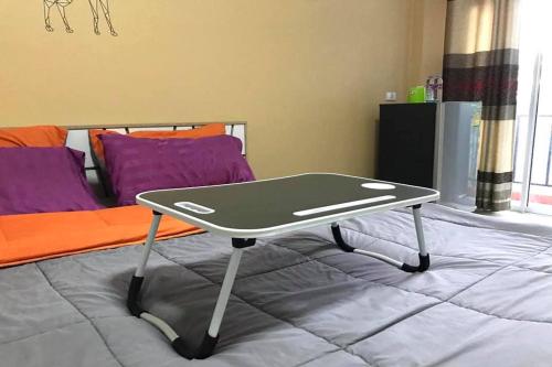 班昌The Hope Apartment的一张乒乓球桌,坐在床上