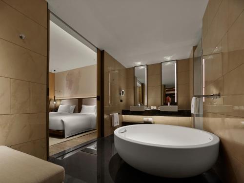 珠海珠海横琴悦椿酒店的带浴缸的浴室和1间带1张床的卧室