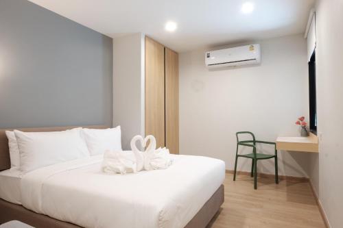华欣Maleesa Place Hua Hin的卧室配有白色的床和书桌