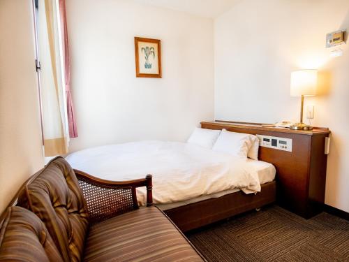 小牧市小牧シティホテル的小房间设有床和沙发