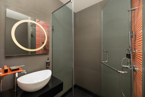 新德里姜东德里酒店的一间带水槽和玻璃淋浴的浴室