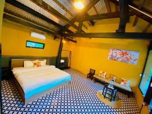 木州县Moc Chau Retreat的卧室配有一张床铺,位于一个黄色墙壁的房间