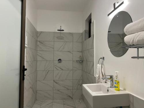 基利菲Lihanda Villa B1的带淋浴和盥洗盆的白色浴室